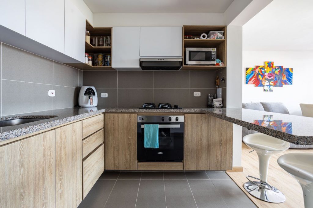 Contemporary kitchen with wood cabinets and integrated appliances in Bogotá home.