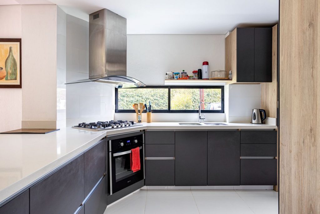 Sleek modern kitchen interior in Chía, Colombia with dark cabinets and stainless steel elements.