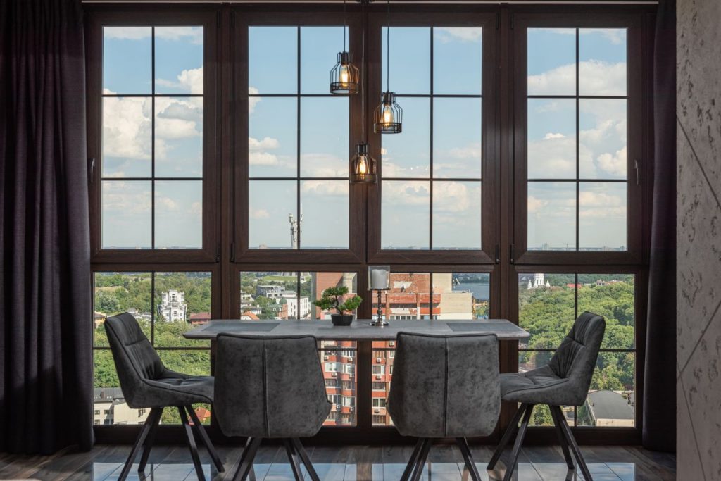 Stylish dining room with large windows overlooking a vibrant cityscape.