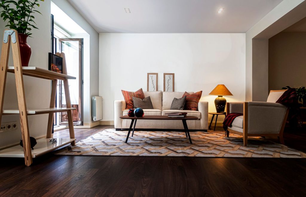 Elegant living room in Madrid featuring a modern sofa, stylish decor, and ample natural light.